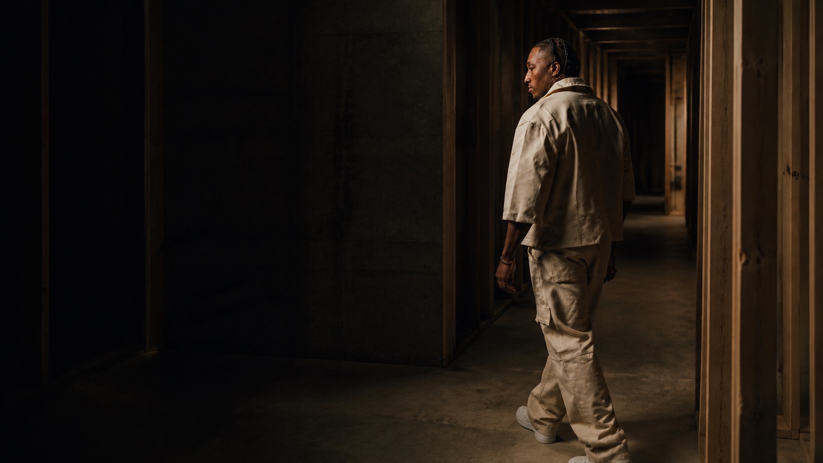 Lecrae walking through an unfinished corridor